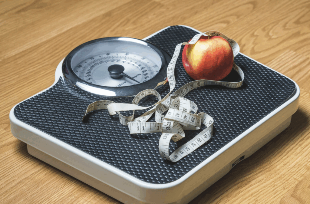 scale with measuring tape and apple on it